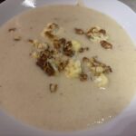 Blumenkohlcremesuppe im Teller mit gerösteten Blumenkohlstücken und Schnittlauch