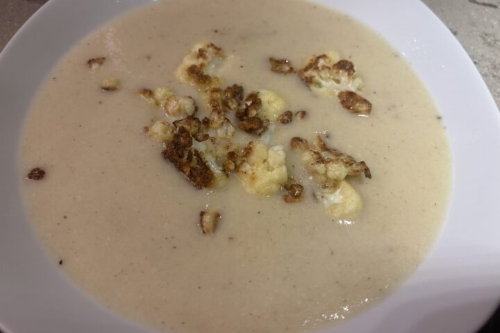 Blumenkohlcremesuppe im Teller mit gerösteten Blumenkohlstücken und Schnittlauch