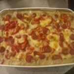 Ein Teller Polenta‑Auflauf mit cremiger Polenta, buntem Gemüse und goldbrauner Oberfläche.