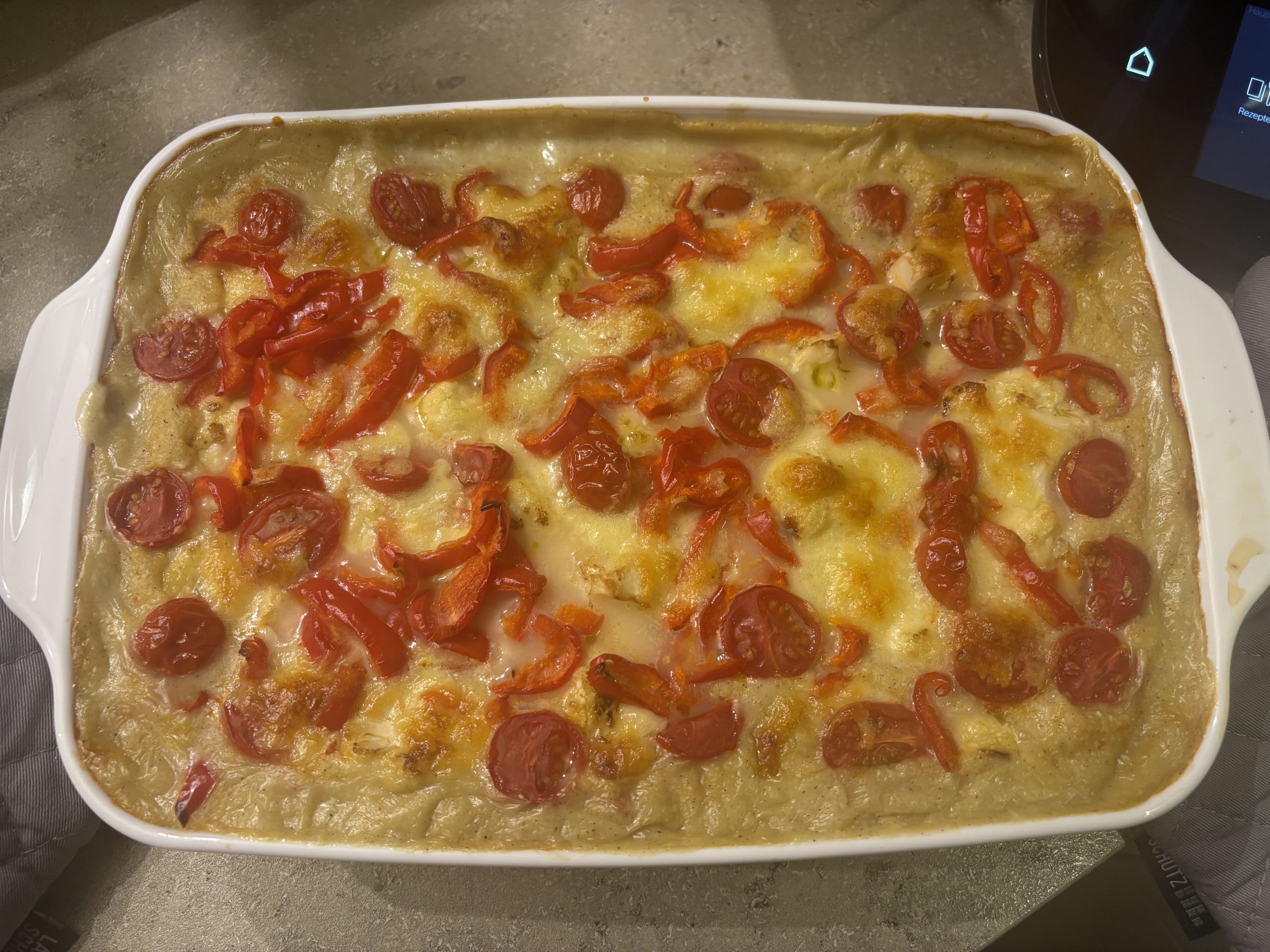 Ein Teller Polenta‑Auflauf mit cremiger Polenta, buntem Gemüse und goldbrauner Oberfläche.
