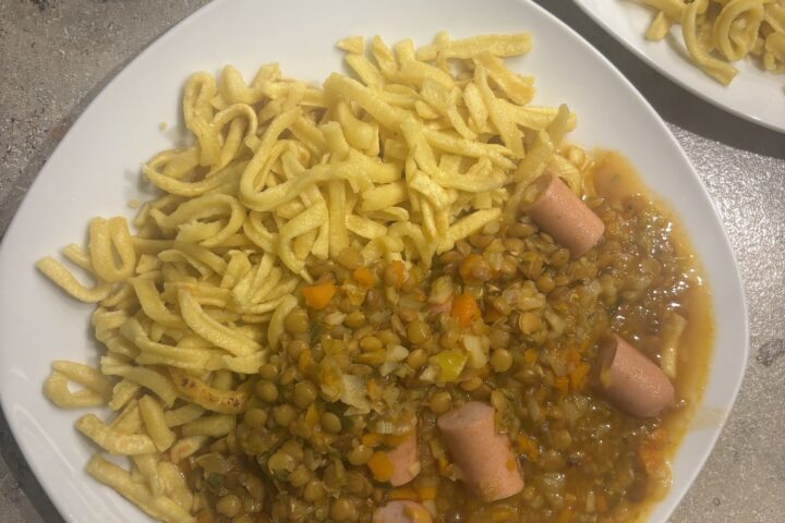 Ein Teller Schwäbische Linsensuppe mit Linsen, Gemüse und Würstchen, serviert als herzhaftes Hausmannskost‑Gericht.