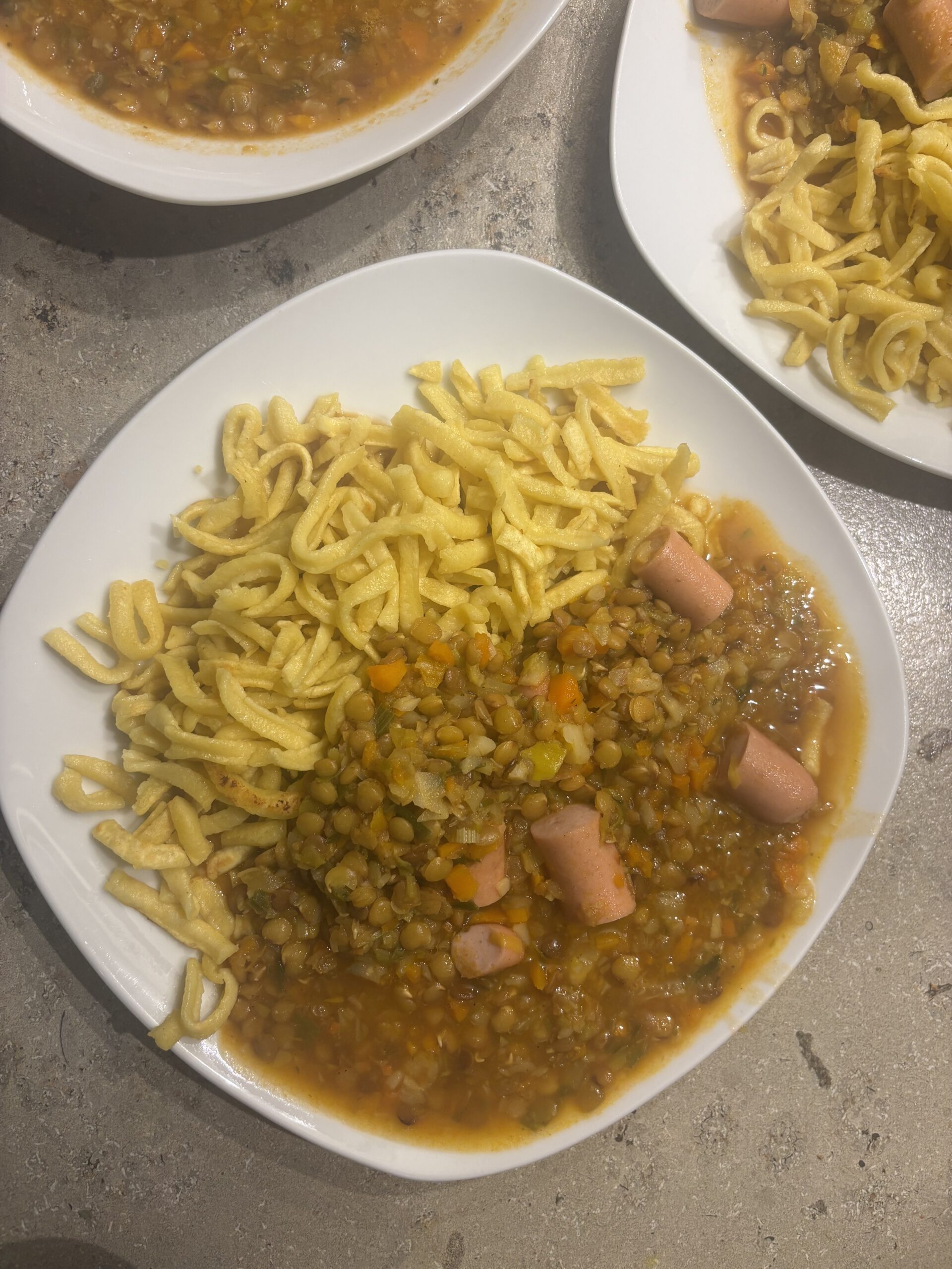 Ein Teller Schwäbische Linsensuppe mit Linsen, Gemüse und Würstchen, serviert als herzhaftes Hausmannskost‑Gericht.