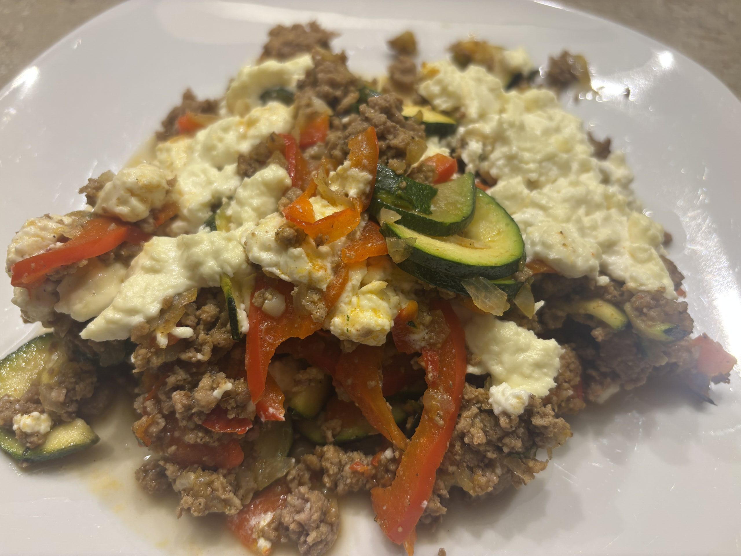 Auflaufform mit Hackfleisch-Feta-Auflauf voller Gemüse, frisch aus dem Ofen