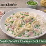 Cremige Tortellini mit Schinken und Erbsen in einer Schale serviert