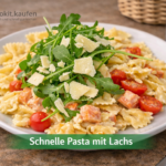 Teller mit Farfalle‑Pasta, Lachs, Kirschtomaten, frischem Rucola und gehobeltem Parmesan, angerichtet als schnelles Cookit Rezept „Schnelle Pasta mit Lachs“.