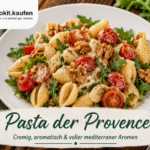 Pasta der Provence mit Muschelnudeln, cremiger Kräutersauce, Cherrytomaten, Walnüssen und frischem Rucola auf einem weißen Teller.